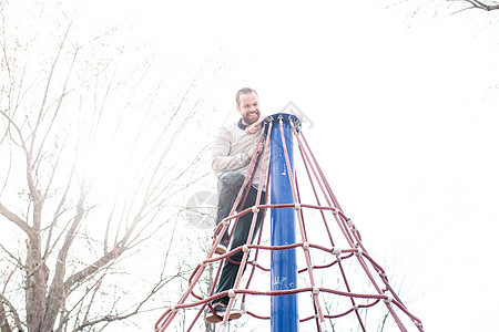 在公园的蜘蛛网塔顶上的男人图片