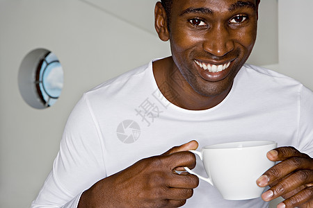 男人拿着茶杯看着镜头微笑图片