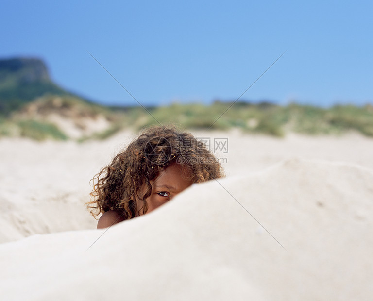 女孩躲在沙堆中图片