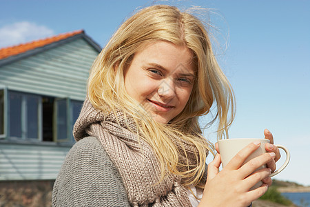 喝咖啡或茶叶的年轻妇女图片