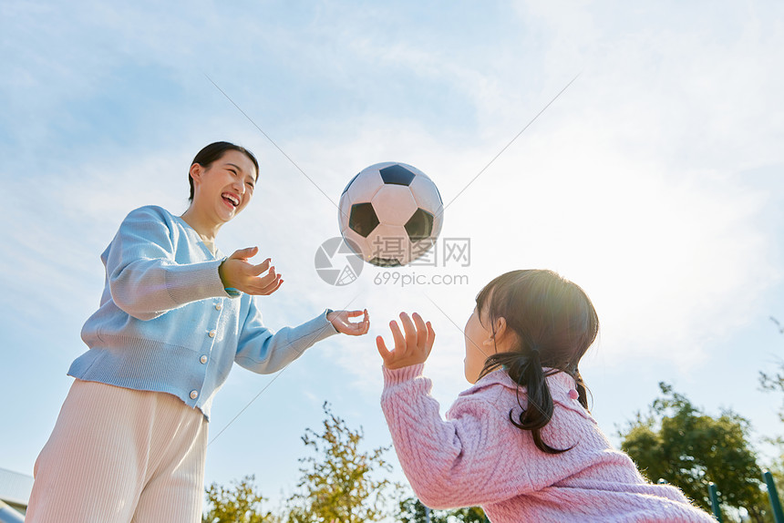 妈妈陪女儿户外玩耍踢足球图片