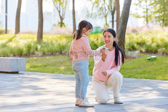 妈妈陪女儿户外郊游玩纸飞机图片