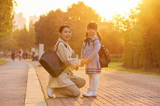 夕阳下妈妈与女儿牵手形象图片