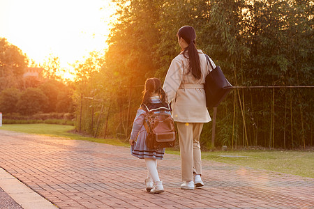 夕阳下妈妈接女儿放学回家背影背景图片