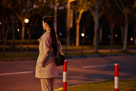 马路背影夜晚职场女性下班等红绿灯背景