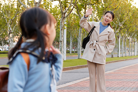 妈妈与上学的女儿挥手说再见背景图片