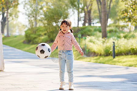 小女孩在户外玩耍踢足球图片