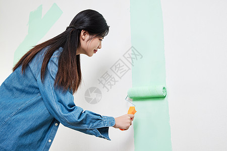 青年女性室内粉刷墙面图片