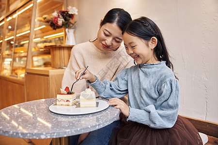 母亲跟女儿在甜品店吃蛋糕图片