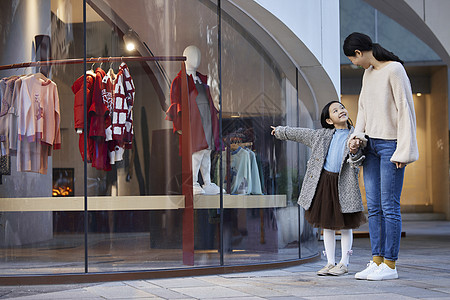 冬季橱窗妈妈带女儿逛街买衣服背景