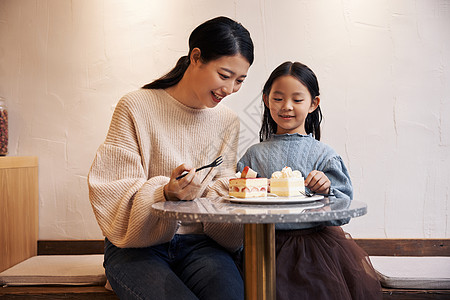 母亲带女儿甜品店吃蛋糕图片