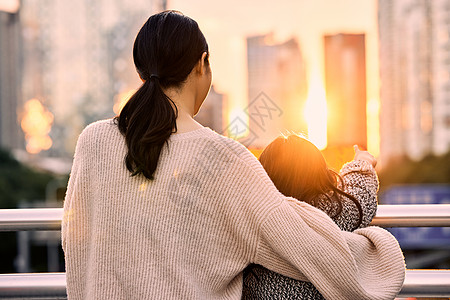 母女合影夕阳下母女站在天桥上的背影背景