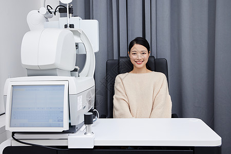 坐在验光机器前检查视力的女性图片