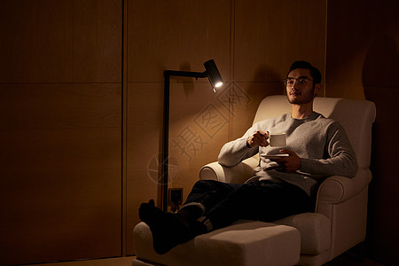 成熟男性躺在沙发上喝咖啡高清图片
