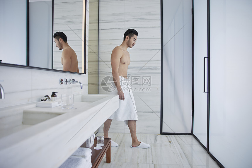 成熟男士裹着浴巾进入洗手间图片