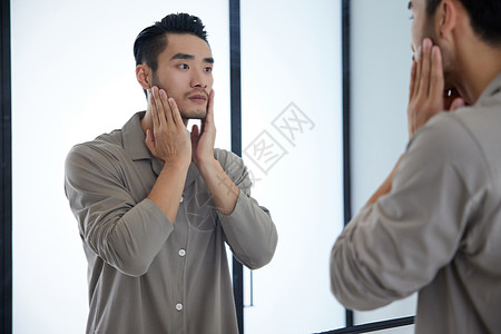 成熟男士对着镜子护理皮肤图片