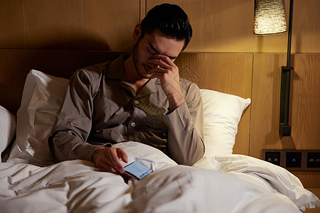 健康家居生活熬夜看手机眼睛疲劳的男性背景