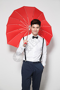 青年人满意亚洲青年男人拿着心形红雨伞图片
