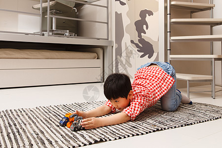 娱乐室小男孩在地毯上玩耍图片