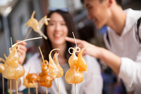 大学生消费幸福快乐情侣街边看糖人背景