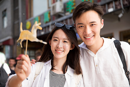 大学生元素快乐情侣街边拿着糖人背景