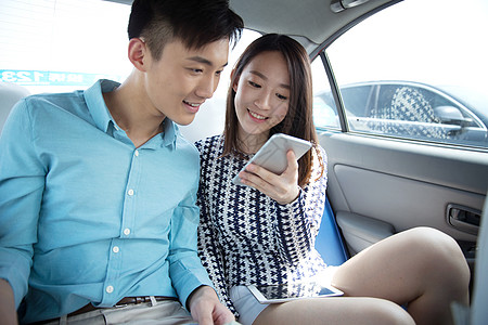 青年情侣在车内看手机图片