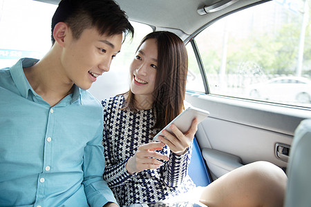 快乐青年情侣在车内看手机图片