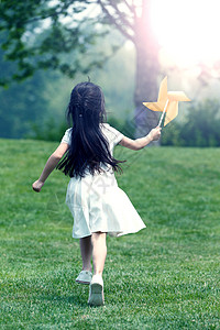 小孩动作幸福小女孩在草地上玩耍背景