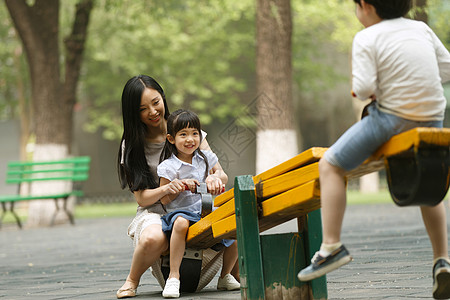 儿童玩跷跷板休闲活动无忧无虑不看镜头快乐母女玩跷跷板背景