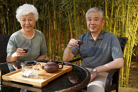 老年娱乐老年夫妇在院子里喝茶背景