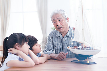桌子亚洲童年祖父陪孙辈在客厅玩耍图片
