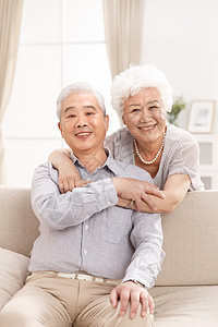 老年女人关爱注视镜头幸福的老年夫妇在客厅图片