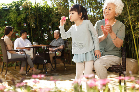 夏天幸福家庭在庭院里吹泡泡图片