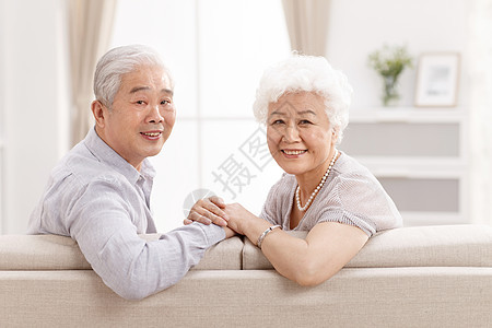 侧面视角沙发老年伴侣幸福的老年夫妇在客厅图片