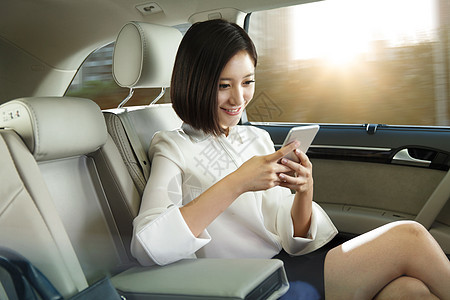 青年女人坐在汽车里看手机图片