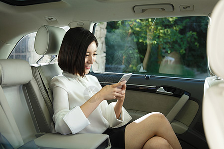 车互联网汽车内部青年女人坐在汽车里看手机背景