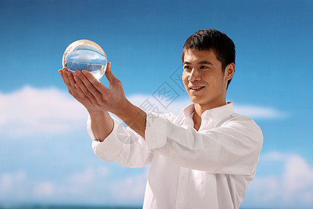 海边手捧玻璃球的男性图片