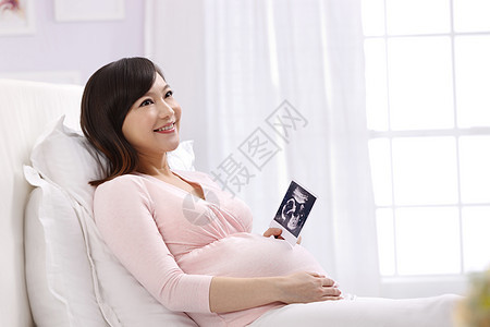 时尚东亚生长孕妇拿着超声波照片图片