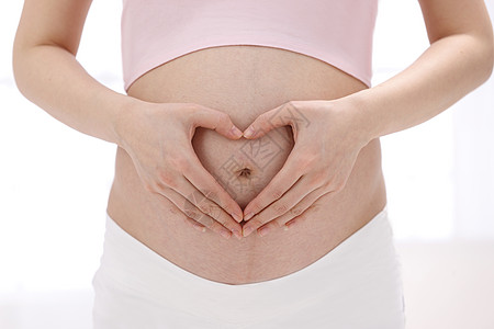 女人满意身体保养孕妇在肚子上做心形手势图片