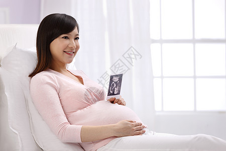 新生活放松仅女人孕妇拿着超声波照片图片