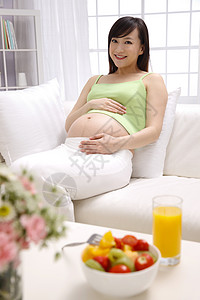 茶几上的食物手放在肚子上的孕妇背景