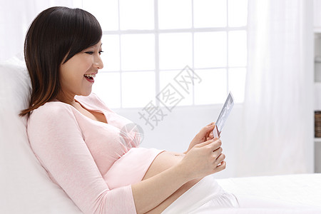 幸福医疗诊断工具关爱孕妇拿着超声波照片图片