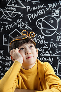 孙悟空造型的小男孩坐在黑板前图片
