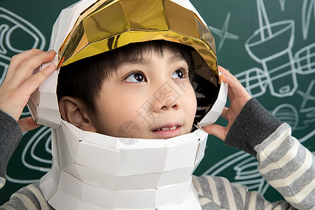 戴着航天员头盔的小男孩站在黑板前图片