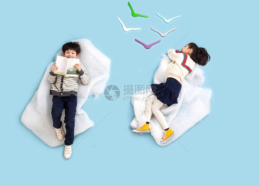 快乐儿童躺在云彩上看书玩耍图片