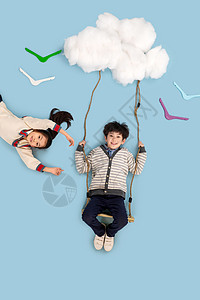 躺着兄弟姐妹仅儿童快乐儿童在云彩上荡秋千图片