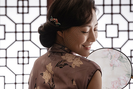 中式穿旗袍的东方女人和扇子图片