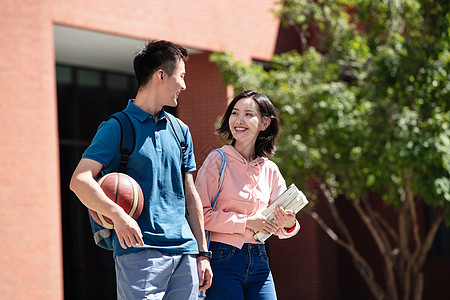 抱着花的情侣大学生情侣在校园里散步背景