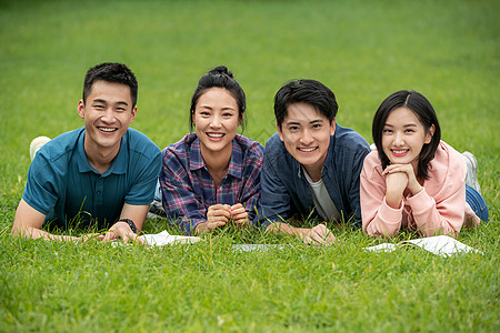 四个人快乐的青年大学生趴在草地上高清图片