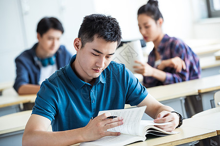 成人学习课桌大学生在教室内学习背景